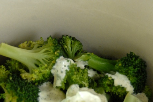 broccoli with creamy lemon herb sauce shown in mixing bowl